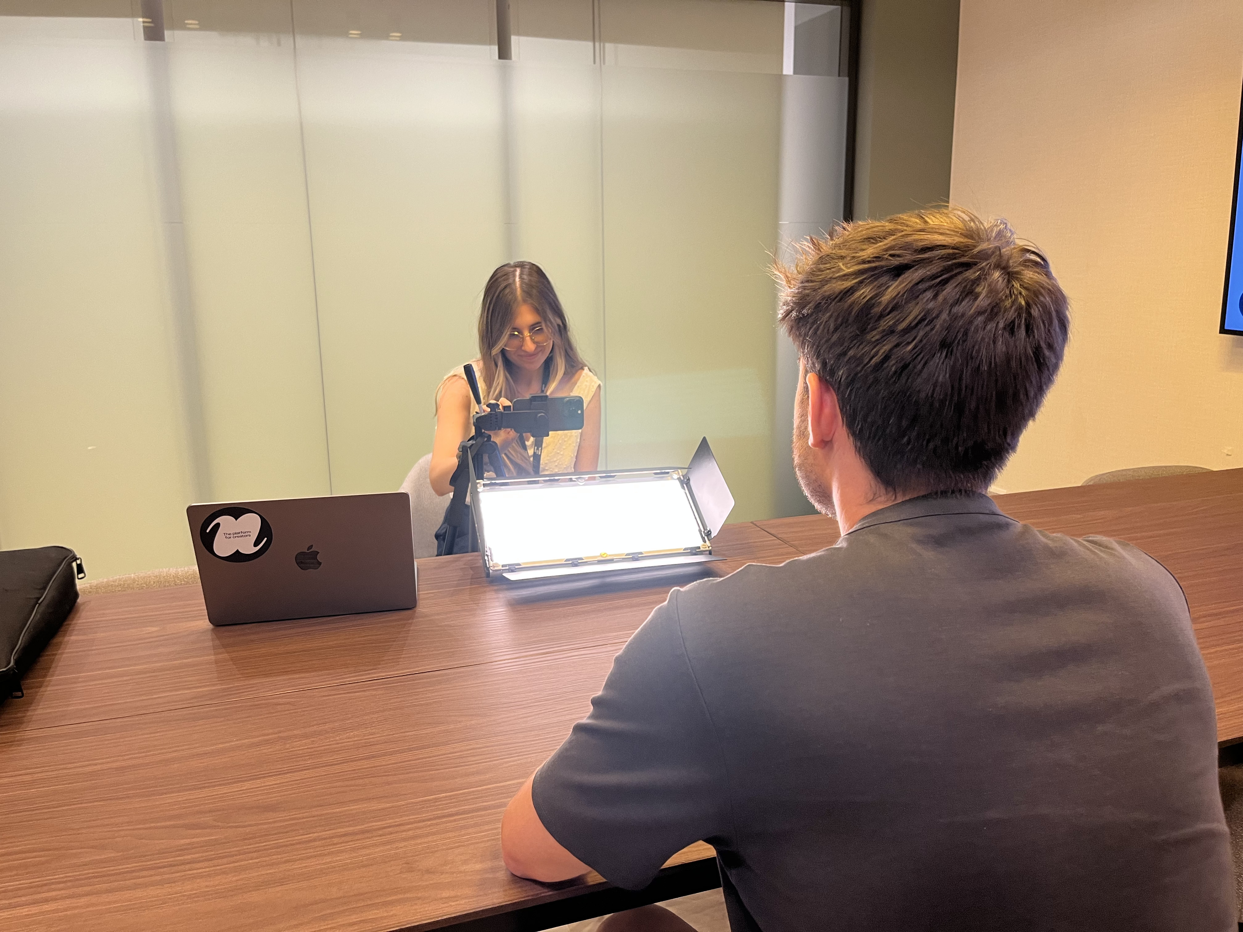 Grabando con el móvil y un panel de luz en una sala de reuniones